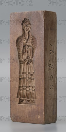 Double-sided gingerbread mould. Side A: figure of a lady in a decorative, pleated early 19th-century dress, holding a bouquet of roses. Side B: stylised fish in profile covered with scales. Rectangular wooden mould, double-sided. Edge engraved with date 1808 and, in the middle of the date, the letter S against an anchor mark of the woodcarver/gingerbread maker. Material: wood; function: gingerbread mould; motifs: female figure, flowers, fish, zoomorphic and folk motifs; style: decorative/folk. Origin: Silesia Province of Silesia, 1742–1918. Dimensions: height 19.8 cm, width 7.3 cm, depth 4 cm. Maker: unknown woodcarver or gingerbread maker., A tall rectangular wooden block with a carved recessed figure of a person wearing a long textured dress and detailed hair is shown standing upright; the block has a warm brown color with variations of lighter and darker brown tones, smooth worn surfaces and visible wood grain, and the carved figure shows carved patterns and depth with shadowed inne...