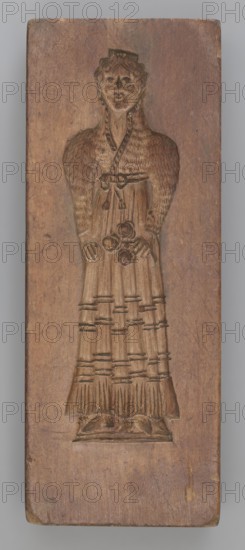 Double-sided gingerbread mould. Side A: female figure in a decorative, pleated early 19th-century dress, holding a bouquet of roses. Side B: stylised fish covered with scales shown in profile. Rectangular wooden mould, double-sided. Edge engraved with the date 1808 and, centered in the date, the letter S against an anchor mark of the woodcarver/gingerbread maker—owner of the form. Materials: wood; function: gingerbread mould; motifs: fish, flowers, female figures in rich historical costume, zoomorphic and folk motifs. Maker: unknown woodcarver or gingerbread maker. Origin: Silesia Province of Silesia, dated 1808. Dimensions: height 19.8 cm, width 7.3 cm, depth 4 cm., A carved wooden panel shows a full-length relief of a standing figure with a rounded head and stylized facial features, curly hair, and a small headpiece. The figure wears a long, detailed dress with a textured upper section suggesting a patterned or feathered texture and a skirt with vertical pleats and horizontal bands. ...