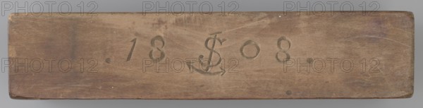 Double-sided gingerbread mould. Side A: figure of a lady in a decorative, pleated early 19th-century dress holding a bouquet of roses. Side B: stylised fish in profile, covered with scales. Rectangular wooden mould, double-sided. Edge engraved with the date 1808 with the letter S over an anchor mark of the woodcarver or gingerbread maker. Materials: wood; function: form for gingerbread. Dimensions: height 19.8 cm, width 7.3 cm, depth 4 cm. Origin: Silesia Province of Silesia, 1742–1918; folk/decorative art; motifs: female figure, flowers, fish, historical costume, zoomorphic. Maker: unknown woodcarver or gingerbread maker. Provenance: unknown., A rectangular wooden plank with a smooth worn surface and rounded corners, showing a few shallow scratches and scuff marks; the wood displays various shades of brown with areas of darker brown and subtle reddish-brown tones, plus hints of gray near the edges; along the center are carved shapes and shallow indented marks; the background behind th...