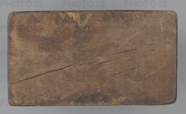 Double-sided gingerbread mould. Side A: figure of a lady in a decorative, pleated early 19th-century dress holding a bouquet of roses; Side B: stylised fish shown in profile, covered with scales. Rectangular wooden mould, double-sided. Edge engraved with date 1808 with the letter S over an anchor mark of the woodcarver/gingerbread maker and owner of the form., wood; decorative folk motifs, historical costume, zoomorphic motif. Maker: unknown woodcarver or gingerbread maker. Origin/provenance: Silesia Province of Silesia, circa 1808. Function: gingerbread mould. Dimensions: height 19.8 cm; width 7.3 cm; depth 4 cm., A worn rectangular wooden surface with rounded corners occupies the image, showing a weathered brown tone with variations of darker and lighter brown patches, small areas of blackish discoloration, and hints of yellowish wear near the top edge; the wood grain and several long cracks and fine scratches run across the surface, and the edges show smoother, slightly darker brown...