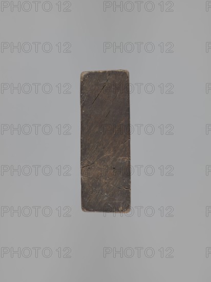 Double-sided gingerbread mould. Obverse: image of Madonna and Child; reverse: small image of Madonna in oval. Double-sided, rectangular form; on one side a figure of Madonna and Child, with a crown on her head, in a long patterned robe decorated with various geometric and plant motifs, the Madonna holds the Child in her left hand and a sword in her right; the other side: a smaller figure of the Madonna in an oval, surrounded by rays, the whole surrounded by a laurel wreath. Materials/function: gingerbread mould; iconography: Madonna and Child, wreaths, crown, sword, religious motifs, female figures in rich dresses, folk motifs; decorative art. 19th century, Province of Silesia 1742–1918. Dimensions: height 25.8 cm, width 12 cm, depth 4.5 cm., A rectangular dark brown wooden block with worn edges and visible cracks suspended against a smooth light gray background, showing variations of darker and lighter brown grain and small areas of tan discoloration.