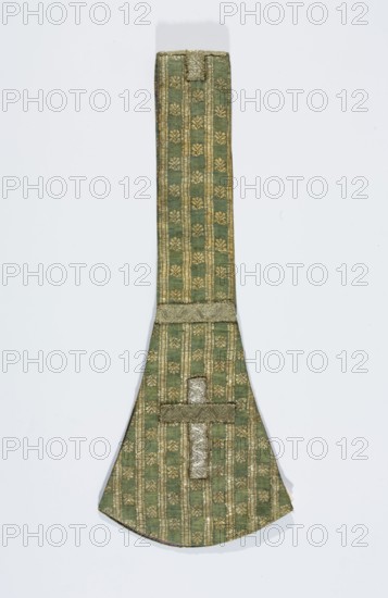 Maniple, liturgical vestment, silk fabric with a fine pattern of stylised floral motifs between gold stripes; lined with linen. Crosses on gold galloon paddles. Fabric background in simple weave warp celadon, wefts blue, brocaded with silver metal thread with a loose braid on a white silk base. 18th century, Grodno, Poland. Length 83 cm, width 16 cm., A long narrow textile object with a wider rounded end, shown against a pale background; the fabric is green with a repeating decorative pattern in metallic gold forming vertical stripes and small floral-like motifs; there is a horizontal band of textured metallic trim near the wider end and another strip of metallic trim forming a short cross-like shape on the rounded section; the overall colors visible are green and gold with subtle variations in shading and a soft shadow beneath the object.