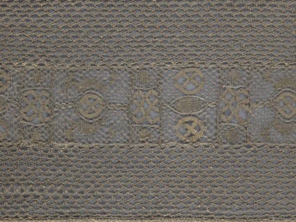 A so-called Saxon lace belt, lace belt/clothing accessory for men's clothing. The central part is a continuous belt with a geometric ornament; among the motifs is a circle containing an hourglass. Side belts of similar width are permanently connected. The entire belt is trimmed with fringe. 17th–18th century, Poland. Materials: lace. Dimensions: height 270 cm, width 25 cm., A detailed close-up of a fabric with an openwork, net-like pattern featuring a horizontal band of decorative motifs across the middle; the textile appears in shades of beige and light tan against a muted grayish background, with a repeating lattice of knotted loops above and below the central band and a row of various circular and oval embroidered shapes and textured fills within rectangular frames in the central area, all rendered in the same beige tones.