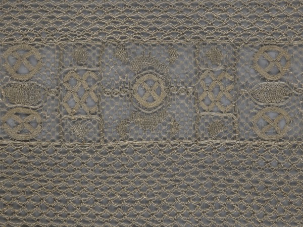 A so-called Saxon lace belt, lace belt accessory for men's clothing. The central part is a continuous belt with a geometric ornament; among the motifs is a circle containing an hourglass. The side belts of similar width are permanently connected. The entire belt is trimmed with fringe. 17th–18th century, Poland. Materials: lace; height 270 cm, width 25 cm., The image shows a close-up of a patterned textile or mesh with an intricate woven design in beige and gray tones; a few areas feature circular and diamond-shaped woven motifs connected by a network of looping threads, and a larger section displays a repeating net-like lattice; the background appears gray while the woven elements are beige, creating a contrast between the two colors.