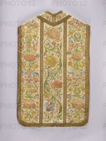 Chasuble, Liturgical vestment made of white silk satin, embroidered with colorful silk threads. The columns feature a wide, richly flowered tendril with large flowers in the bends and small ones along the tendrils. The sides are decorated with floral sprigs placed one above the other and growing from heart-shaped vases. Predominant colors: pink in several shades, green, and blue. Edges trimmed with wide gold braid, columns with narrower braid. Cotton lining, light pink. Dated 1st half of the 19th century with an 18th-century association, place of origin: Poland. Length 107 cm, width 66 cm back. Subjects/ornament: flowers, plant tendrils, plant ornaments; function: church paraments, sacred art, churches and chapels furnishings., A fabric panel with a symmetrical, vertical design framed by a textured border in a warm gold tone, featuring three vertical panels filled with ornate floral embroidery in pastel colors including pale pink, soft green, light blue, muted yellow, and cream; the ce...