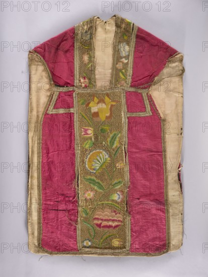 Chasuble, Liturgical vestment, 1797, Poland. Back features a column embroidered with colorful silks in large flowers on a gold background; sides in amaranth silk taffeta; front sides in red taffeta. Columns embroidered on a gold background in zigzag twig patterns with large stylized flowers. Trimmed with silver braid in a diamond pattern with gold stripes. Cotton lining. Length 114 cm, width 73 cm back., A worn textile garment laid flat, featuring a central embroidered panel with floral motifs and leafy stems in colors including yellow, green, blue, pink, and brown set against a metallic gold background, flanked by panels of deep pink silk and bordered by a pale cream fabric; the piece shows fraying and loose threads, areas of wear and discoloration, and visible seams and stitching throughout.