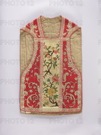 Chasuble, liturgical vestments, Anthony of Padua St.; 1195–1231 — iconography, plant ornaments, church paraments, sacred art, churches and chapels furnishings. Column at the back of the chasuble: at the top in an oval embroidered, kneeling St. Anthony, below branches of apple blossoms and fruit. Column at the front: branches with apple blossoms and fruit. Sides: ornament with stylized plant twigs. The whole is trimmed with white lace from the period. Predominant colors: white for the columns, red for the sides, and yellow, pink, blue, and white for the ornament. Cotton lining. 17th century, Poland; liturgical vestment; length 95 cm, width 60 cm back., A garment panel with a central vertical panel framed by a wider border, showing a silk fabric in beige and deep red with decorative embroidery and lace trim; the central panel features floral embroidery with branches and flowers in green, pink, yellow, blue, and brown on a beige ground, while the surrounding areas are deep red with cream ...