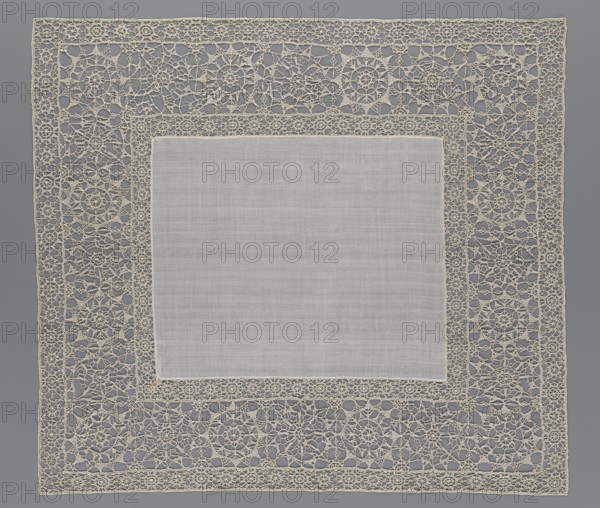 Doily, geometric ornaments; rosettes ornament; doilies; smooth center. Edge made of white linen lace with rosette motifs: large rosettes in the center and rows of small rosettes on the edges; punto in tela lace; ca. 1600, Italy. Materials: lace, fabric. Height 79 cm, width 70 cm., A square cloth with a plain central panel in a light grayish-white color is surrounded by an ornate openwork lace border in an off-white or cream color; the lace border features repeating circular and floral motifs interconnected by fine looping threads, forming an overall delicate, geometric network, and the piece is set against a medium gray background.