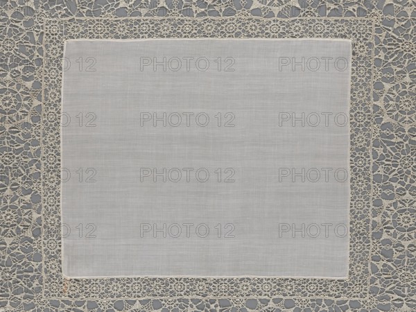 Doily, geometric ornaments; rosettes ornament; doilies. Smooth center. Edge made of white linen lace with rosette motifs: large rosettes in the center and rows of small rosettes on the edges; punto in tela lace; ca. 1600, Italy. Materials: lace, fabric. Height 79 cm, width 70 cm., A square piece of light gray fabric with a smooth, slightly textured surface sits centered within an ornate openwork border; the border is a delicate lace in an off-white or cream color featuring repeating circular and web-like motifs, and it contrasts with a darker gray background visible through the lace openings.