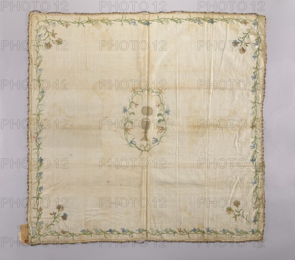 Church napkin made of linen fabric with a rare plain weave. Embroidered with chain stitch using colored silk and gold thread also pierced. In the center, in a wreath of flowers tied with ribbon, is a gold chalice, and above it a gold oval—probably a patera, not a host. In the corners are floral sprigs tied with a ribbon with double loops. A floral tendril runs around the edges. The flowers are stylized, not decorative. Flower colors: green, brown, blue, sky blue, pink, tobacco. Narrow gold lace sewn around the edges now very damaged. Fabric density: 30 weft threads, 23 warp threads per cm. Second half of the 18th century, Poland. Materials: linen, silk, gold thread. Dimensions: height 100 cm, width 105 cm. Subject: church paraments, sacred art; motifs: flowers, leaves, plant ornaments., A large square cloth with a pale off-white background that shows faint creases and light stains, bordered by a decorative vine-like embroidery in green threaded along the edges with small floral motifs ...