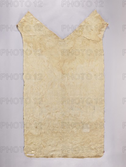 Back of a chasuble made of cream silk rep, embroidered with patterns of various flower branches, palm trees, and leaves in no specific composition. Probably adapted into a chasuble from another object. Embroidery in colored silk thread using flat and satin stitches and smooth, slightly crimped gold thread. Gold and pastel colors: blue, green, yellow, red, pink. 17th–18th century, Poland. Liturgical vestment. Length 133.5 cm; width 72 cm., A large, roughly rectangular textile or paper sheet with a V-shaped cut at the top, hanging against a pale gray background; the surface is textured and uneven with visible creases and a worn appearance, showing an overall pale beige or off-white color with subtle washes of light yellow and faint pinkish or tan markings; the edges are irregular and slightly frayed, and a small square patch of slightly different texture is visible toward the lower right area.