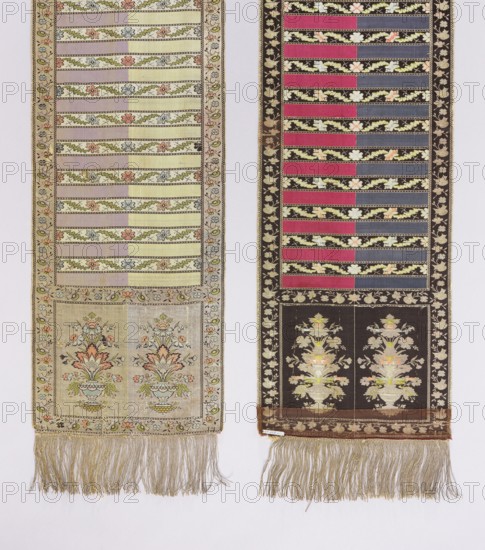 Kontusz belt, floral bouquets ornament, solid belt, vase ornament, four-sided belt, plant ornaments, Polish belt, Polish costume, kontusz belt, belt, Poland culture, signatures, fashion accessory, clothing accessory, men's clothing accessory, bipartite heads with bouquets of flowers in decorative vases alternating with plant tendrils and plain. Colors: silver, crimson, celadon, blue, yellow, and purple. Signed at the bottom of the heads: PI. 2nd half of the 18th century, Lyon place of origin, national costume accessory. Length 358.5 cm, width 29.5 cm., Two narrow woven panels hang side by side against a pale background, each with decorative horizontal bands and fringed bottoms. The left panel shows a series of alternating pale stripes and floral vine bands in soft colors including cream, light yellow, pale green, dusty pink, muted blue, and coral, with a framed lower section featuring two identical vase motifs with stylized flowers in peach, green, and blue on a beige ground; its fring...