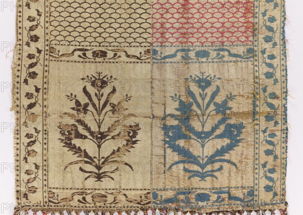 Kontusz belt, Flower bushes ornament; solid belt with carp-scale ornament; four-sided belt with plant ornaments. Polish kontusz belt, men's clothing accessory. Bipartite heads with flower-bush motifs; carp-scale pattern continues. Edge with motif of small flower-sprig tendrils. Colorful silk fringe, sewn on. Colors: gold, brown, silver, and blue. Signed at the bottom of the heads: FS lying. 2nd half 18th century. Possibly Slutsk, Grand Duchy of Lithuania 1569–1795 / Poland. National costume accessory. Length 356.5 cm, width 28.5 cm., A woven textile with a patchwork layout showing a few vertical panels and a group of rectangular sections, featuring floral and scallop motifs; the left side has darker brown floral patterns on a beige background with a narrow border of small repeating floral elements, the right side shows similar floral motifs in blue on a beige ground with a vertical blue vine-like border, the top right contains a scalloped pattern in pink on beige, and the top left has ...