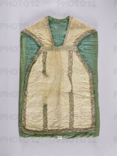 Chasuble, unknown creator; liturgical vestment, 18th century, possibly France. Against a background of broken lines, wavy-winding sprigs of large flowers are arranged. Division into columns is emphasized by stitching of silver lace, supplemented in places with a different type. Remnants of decorative stitching of green glass beads and sequins. Lining made of thin green silk. Length 103 cm; width 68 cm back. Width of report 27.5 cm; height of report 36–38 cm. Repossession, An ornate garment displayed flat against a pale background, predominantly cream and green in color, with cream panels bordered by metallic trim and green side and interior panels; the cream fabric shows visible creases and a slightly glossy texture, and the green fabric appears matte with a softer sheen; decorative scalloped metallic trim runs along seams and edges, creating vertical and curved lines on the front, and there is a gathered neckline area at the top.