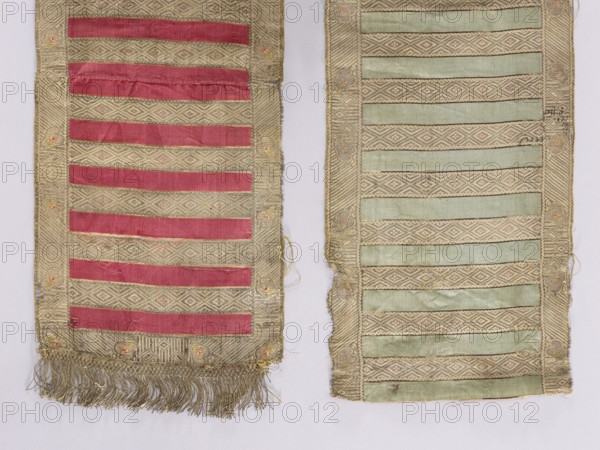 Fragment of a kontusz belt; Polish; 18th century; Gdansk place of origin. Double-sided, semi-solid men's clothing accessory kontusz belt for national costume; length 150 cm, width 26.5 cm. Geometric-floral ornament: transverse plain stripes and alternating geometric ornaments rhombuses with rosettes; border ornamented with diagonal stripes with a pattern of leaves and small rhombuses. Colors: blue, gold, and red., The image shows two long narrow textile panels side by side on a pale background; the left panel has a patterned beige base with horizontal strips of deep red fabric and a fringe of beige-gold threads at the bottom, while the right panel has a similar patterned beige base with horizontal strips of pale green fabric and a frayed lower edge. The patterned areas feature diamond and linear woven motifs in beige and light gold tones, and there are small circular embroidered accents in muted pink and gold along the borders. The textiles show signs of wear with some loose threads, f...