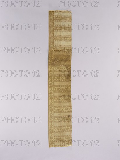 Fragment of a kontusz sash, Studio of Franciszek Maslowski belt manufacturer; 1781–1806, Kraków. Sewn from two pieces; still with crosswise stripes. Edge with floral tendril. Colors: straw, brown, pink. Ornament Center: with transverse shelves, alternating: shelf A with crescent and star motifs, shelf B with rosette motifs, shelf C with a floral tendril motif. Vertical borders: with a trailing flowered branch. Borders: with serrated and ladder patterns. Colors Front: background of borders and shelves with tendril is straw, brown ornament; background of shelves with crescents is brown, cream ornament; background of the shelves with rosettes is straw and light faded pink. Reverse: original reverse. Without fringes. Weave density: approx. 19/30 x2 This fragment is a remnant of Maslowski's signed belt. It represents the type of belts from his workshop and features identical motifs to those on belt inventory no. SZT 428. The crescent motif placed in the shelves is characteristic of this bel...