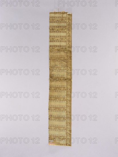 Fragment of a kontusz sash, Studio of Franciszek Maslowski belt manufacturer; 1781–1806. Polish sash fragment, sewn from two pieces; still with crosswise stripes. Edge with floral tendril. Colors: straw, brown, pink. Ornament - Center: transverse shelves alternating: shelf A with crescent and star motifs, shelf B with rosette motifs, shelf C with a floral tendril motif. - Vertical borders: trailing flowered branch. - Borders: serrated and ladder patterns. Colors - Front: background of borders and shelves with tendril is straw with brown ornament; background of shelves with crescents is brown with cream ornament; background of shelves with rosettes is straw and light faded pink. - Back: reverse of the original. Without fringes. Weave density: approx. 19/30 x2. This fragment is a remnant of Maslowski's signed belt, representing the type of belts from his workshop; the crescent motif in the shelves is characteristic of this manufacturer's products and not found on belts from other Persian...