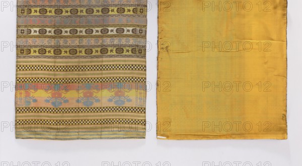 Kontusz belt, 18th century, Russia. Men's clothing accessory one-sided kontusz belt. Silk, fabric with three-and-a-half-section heads showing motifs of flower bouquets in inverted vases and fine belts in a checkerboard pattern or with narrower stripes belts vary in color. Horizontal stripes with a motif of rosettes with flowers. Ornament: flower bouquets. Colors: beige, brown, yellow, cream, green, blue, pink. Dimensions: length 210 cm, width 48 cm., The image shows two adjacent fabric panels against a pale background: the left panel has alternating horizontal patterned bands with a palette including yellow, brown, pale blue, pale pink, and green, featuring geometric checkerboard stripes and floral or rosette motifs; the right panel is a solid mustard yellow fabric with subtle discolorations and faint marks, and both panels show folded edges and slight creases.
