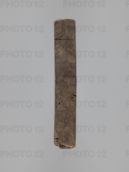 Double-sided gingerbread mould. Rectangular; obverse: male figure in 18th-century attire tricorn hat, justaucorps, culottes, long boots sitting on a goat, carved inscription at bottom: EIN SCHÖNER BOCK EIN GUTER / PFERD IST EINER GN ... DIE ZIGE WERT; complemented by plant and floral ornament at base. Reverse: Adam and Eve in Paradise, wearing leaf loincloths, Tree of Knowledge with coiled serpent; at top a bearded figure holding an orb probable God against a heavenly vault with sun, moon and stars; surrounding Adam and Eve are animals cat, deer, bird, cow and squirrel; composition enclosed in a round decorative frame decorated with a plant twig. Materials/function: gingerbread mould; style: folk-style decorations, floral and plant motifs, historical costumes, religious iconography original sin. Date: 18th–19th century. Place/region: Silesia Province 1742–1918. Dimensions: height 21.4 cm, width 24 cm, depth 3.7 cm., A long narrow vertical wooden plank suspended against a pale gray back...