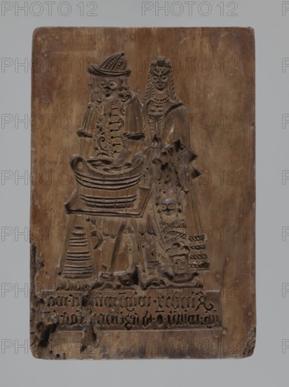 Double-sided gingerbread mould. Obverse: genre scene; reverse: three depictions. Genre scenes, gingerbread mould, babies, children, riders, floral motifs, marriages, plant motifs, decorative and applied art, gingerbread, social satire, rider on a horse iconography. Region: Silesia Prussia; 1742–1918. Description: Double-sided rectangular mould; on one side a genre scene depicting a man standing by a washtub and engaged in washing, behind him a woman holding a baby in swaddling clothes; below a plaque with an inscription in German; made in Schwabach. Second side: three different motifs — at the bottom left, a rider in a hat on a horse; above him a rectangular recess containing a second rectangle with the letters I and B carved, surrounded by geometric and plant ornaments; on the right, another rectangular recess, tripartite, each segment with a vertical strip of floral decoration; above it carved initials A and H. Date: 18th–19th century. Form dimensions: height 24.7 cm, width 16.8 cm, ...