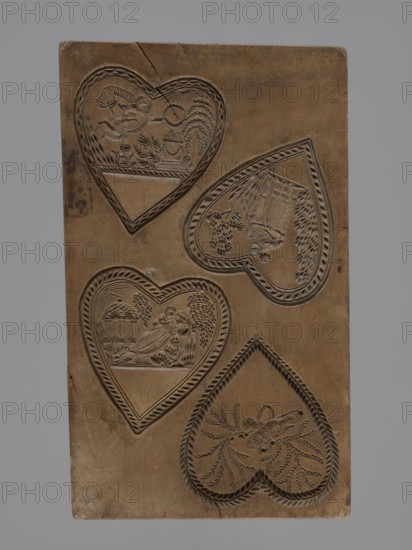 Double-sided gingerbread mould. Obverse: two heart-shaped fields — first: female figure in a long dress sitting among palm trees, holding a wreath, in front of an altar decorated with a garland with fire burning on it, illuminated by sun rays; second: two cupids hovering over an altar decorated with garlands and holding a wreath. Reverse: four hearts, each with a separate scene — first: a bird of paradise sitting among branches; second: a young couple lying on a chaise longue, with a temple illuminated by the sun and trees in the background; third: a cupid holding a wreath, hovering over an altar decorated with garlands with a fire burning, surrounded by trees, bushes and flowers; fourth: a couple in love holding hands surrounded by trees and bushes. Figurative genre scenes with folk-style decorations, hearts, altars, cupids, wreaths, birds, erotic scenes. Applied/decorative folk art, Silesia, 18th–19th century. Form: rectangular double-sided mould. Dimensions: height 23 cm, width 13.8...
