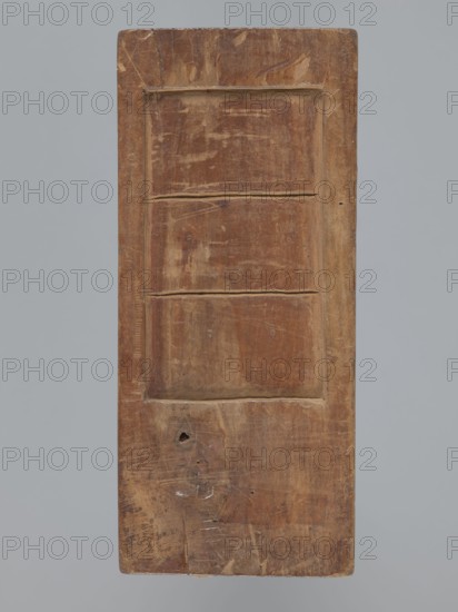 Double-sided gingerbread mold. Obverse: couple holding hands — a woman in a richly decorated long dress with a hat and a man in a caftan and short wig, both in costumes typical of the 18th century; decoration composed of plant elements at the bottom. Reverse: three empty rectangles. Woodcarving; gingerbread mold; genre scene with female and male figures, couples in love, plant motifs. Rectangular. 18th–19th century, Province of Silesia. Height 20 cm, width 8.7 cm., A rectangular wooden panel with a worn, brown surface set against a plain gray background, showing carved rectangular recesses forming a simple three-section pattern; the wood displays scratches, scuffs, small holes, and areas of lighter and darker brown with occasional beige highlights and faint white marks.