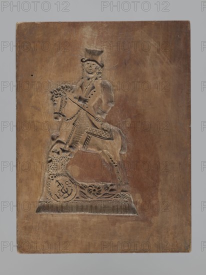 Double-sided gingerbread mould. Rectangular shape, height 25.8 cm, width 19.4 cm, depth 4.3 cm. Obverse: image of a lion with an abundant mane standing on a base decorated with plant-twig ornament, holding a ball engraved with the date 1829 and a symbol of an anchor intertwined with the letter S; floral and plant decoration at the bottom. Reverse: figure of a rider on horseback in early 19th-century riding attire jacket, breeches, top hat, holding a riding crop; at the horse's front legs a round shield engraved 1831 and the same anchor-with-S mark woodcarver or owner mark; floral and plant ornament at the bottom. Materials/type: gingerbread mould, applied art; iconography: figurative scenes, lions, horse, historical costumes, plant motifs. Place/period: Silesia Province of Silesia, 1742–1918., A rectangular wooden panel with a carved relief of a person seated on a horse, both rendered in raised shallow carving; the person wears a tall hat and a coat with visible button-like indentation...