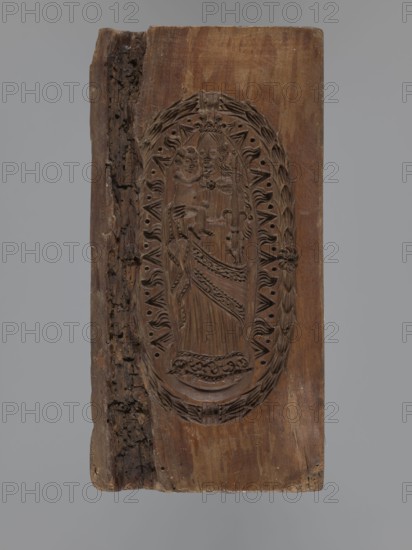 Double-sided gingerbread mould. Obverse: Madonna and Child with a crown, in a long patterned dress, surrounded by a double oval inner frame forming tongues of flame and an outer laurel-wreath frame. Reverse: two standing figures a bachelor and a lady in richly decorated court costumes of the 17th–18th centuries — the man with a long wig, justaucorps, culottes and stockings; the woman with a wig, long dress with a neckline, bottom decorated with a plant tendril. Applied art; decorative art; religious motifs and symbols; plant ornaments. Gingerbread mould, rectangular form. 18th–19th century. Province of Silesia 1742–1918. Height 20.3 cm, width 10 cm, depth 3.5 cm., A rectangular wooden panel with a carved oval relief in the center depicting a standing figure holding a smaller figure, both rendered in low-relief with flowing drapery and detailed facial and hair features; the oval is surrounded by a decorative wreath-like border with leaf and petal motifs and a carved rosette on one side;...