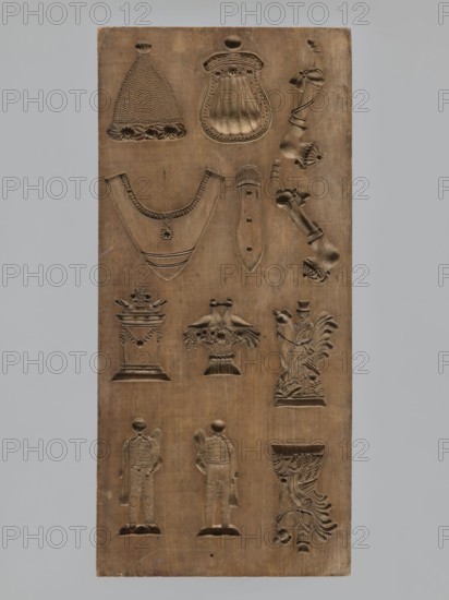 Double-sided gingerbread mould. Obverse: 16 images of various figures; reverse: 12 depictions. Figurative motifs include male figures, female figures, birds, zoomorphic motifs, floral decorations, figurative scenes, and historical costumes. Double-sided rectangular mould; on one side sixteen small images depicting various human figures, male and female, arranged in four equal rows, shown from the front and from the back. The other side: twelve elements including two male figures on a rooster, another in peasant costume, presented in two views front and back; four different elements of clothing; two pipes decorated with tassels; two birds sitting on a flower-filled crater; and a column decorated with a flower garland with two birds on top. Gingerbread mould, applied art, folk motifs. 18th–19th century. Province of Silesia 1742–1918. Height 29.8 cm; width 13.8 cm; depth 3.8 cm., A rectangular wooden panel with a natural brown wood tone carved with a variety of shallow relief shapes arran...