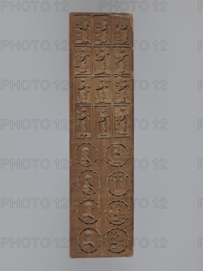 Double-sided gingerbread mould. Obverse: seven floral and plant motifs bouquets of roses and other flowers, two floral wreaths. Reverse: twelve framed images depicting a human figure during farm work and, below, eight medallions with human heads and various animals. Gingerbread; folk-style decorative art with wreaths, human figures, floral and zoomorphic motifs. Rectangular form. 18th–19th century, Province of Silesia 1742–1918. Height 25.3 cm, width 6.6 cm, depth 1.5 cm., A tall rectangular wooden panel with carved reliefs arranged in a grid, showing a group of small standing humanlike figures in the upper portion and a group of circular medallion designs in the lower portion; the panel is brown with darker carved recesses and lighter worn highlights, set against a plain light gray background.