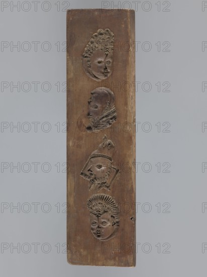 Double-sided gingerbread mould. Obverse: images of four heads; on rotation heads take on male or female appearance in one the male head changes into a goat. Reverse: seven elements in decorative frames: a house roof, a flower, a bird, a plate inscribed IDR / 1763 and another inscribed GFK / 1763, an anchor and cross, decoration complemented by a wreath and flower motif in a medallion. Plant ornaments, human figures, zoomorphic motifs, wreaths, decorative art, religious symbols, inscriptions, folk art. Date: 1793. Region: Silesia Province of Silesia, 1742–1918. Form. Materials: applied art gingerbread mould. Dimensions: height 34.6 cm, width 9.3 cm, depth 2 cm., A vertical rectangular wooden panel with a brown surface displays a vertical arrangement of a few carved human faces in relief, each with distinct hairstyles and facial features; the top face has curly hair and an oval face, the next shows a profile with a beard and textured collar, the middle carving depicts a bearded profile w...