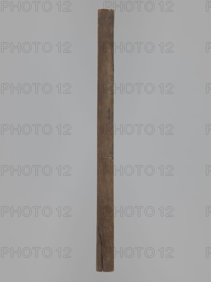 Double-sided gingerbread form. Obverse: image of a rider/trumpeter on a horse dressed in a decorative tail, wearing a costume from the turn of the 18th and 19th centuries long jerkin with wide tails, breeches, long boots, tricorn hat; floral decoration at the bottom. Reverse: four small images of human figures shown front and back — first, male, carrying a basket filled with children probably known in folk tradition as Kinderbringer; second, female, in a high headdress and country dress, holding a handkerchief and a small basket. Gingerbread form, genre scenes, decorative/f olk motifs; Silesia, 18th–19th century. Rectangular form; height 42 cm, width 25.5 cm, depth 2.8 cm., A single vertical wooden plank with a weathered surface and visible grain, showing cracks and small nicks along its length, set against a plain light gray background; the plank is brown with darker brown streaks and some lighter worn areas.