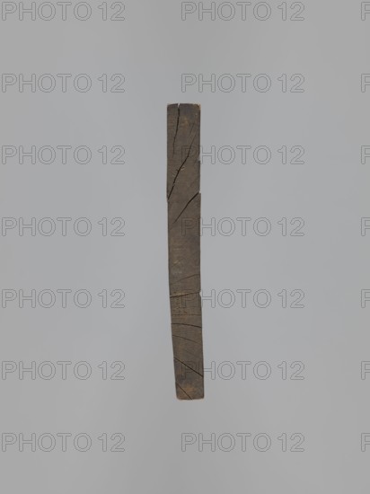 Double-sided gingerbread form. Obverse: image of a rider/trumpeter on a horse dressed in a decorative tail, in a costume from the turn of the 18th and 19th centuries long jerkin with wide tails, breeches and long boots, tricorn hat, with floral decoration at the bottom. Reverse: four small images of human figures shown from front and back — first, male, carrying a basket filled with children probably the folk Kinderbringer; second, female, in a high headdress and country dress, holding a handkerchief and a small basket. Gingerbread mold, genre/folk decorative art, Silesian Province of Silesia, 18th–19th century. Rectangular form; height 42 cm, width 25.5 cm, depth 2.8 cm., A vertical narrow rectangular wooden beam suspended against a plain light gray background, showing a dark brown weathered surface with visible cracks and diagonal fissures along its length, rough texture, and slightly lighter brown at the ends.