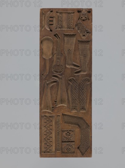 Double-sided gingerbread mould, rectangular, wood, height 29 cm, width 10.5 cm, depth 2.4 cm. Maker inscription on the edge: Glauer: signature of the woodcarver or gingerbread maker and the date j.1827. Dated 1826. One side: twelve small images of animals two horses, two roosters, two crayfish, and two storks carrying babies in baskets and two decorative pipes. Other side: miniature elements including children in swaddling blankets, shoes, footwraps, a cradle, a guitar, and other motifs adorned with plant and geometric ornaments. Decorated with folk, zoomorphic, plant, and geometric motifs; function: form for gingerbread. Silesia Province of Silesia, 1742–1918., A rectangular wooden panel carved with a variety of shallow relief shapes and patterns, showing a few elongated sock-like forms, a guitar-shaped outline, several curved and geometric motifs, and a group of decorative bands and floral-like medallions; the panel surface is brown with darker carved recesses and faint lighter worn ...