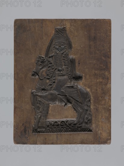 Double-sided gingerbread mould with the image of a rider on both sides, woodcarver or gingerbread maker; gingerbread mould, figurative scenes, riders, male figures, horse iconography, plant motifs, folk-style decorations, applied art, decorative art; Silesia Province of Silesia, 1742–1918; rectangular double-sided mould: one side shows a rider-trumpeter in a tricorn hat in 17th–18th-century costume long caftan, breeches, long boots seated on a horse with decorative tack, both on a base decorated with plant and geometric ornament; reverse shows another rider on horseback probably a hussar wearing a high mirliton cap and a fur-lined jacket, with geometric and floral ornament at the bottom; on one edge the date 1797 is engraved with the letter S against an anchor mark of the woodcarver or owner of the mould; dated 1797; mold; height 19 cm, width 15 cm, depth 5.5 cm., A rectangular wooden block with a carved relief of a mounted figure; the carving shows a person seated on a horse with deta...