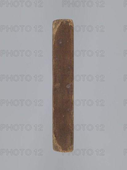 Double-sided gingerbread mould. Obverse: oval frame with a decorative vase of flowers surrounded by a wreath of leaves. Reverse: rectangular recess with a plant ornament, rose motif and the initials E and G. Rectangular shape; mould. 18th–19th century. Province of Silesia 1742–1918. Height 16.5 cm, width 11.5 cm, depth 2.7 cm., A single elongated wooden object is shown vertically against a plain light gray background; the wood is brown with areas of lighter tan wear at the rounded ends and along edges, and its surface shows a few small dents and scratches with subtle variations in grain and tone.