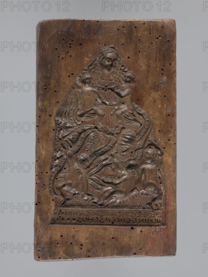 Double-sided gingerbread form. Obverse: image of the Madonna and Child; reverse: two rectangles with floral ornaments. Double-sided rectangular form; on one side a figure of the Virgin Mary in a large patterned robe, surrounded by children—two sitting on her lap, three at her feet—with a German inscription at the bottom: DIE LIEBE IS BEI MIR SO GROS ACH NIM / MICH IN DEINEM SCHOS. The other side: two long rectangular frames filled with floral ornament. Materials: gingerbread decorative art, folk motifs. Iconography: Madonna Christianity, religious motifs, children, plant ornaments. Date: 18th–19th century. Region: Province of Silesia 1742–1918. Dimensions: height 19 cm, width 11 cm, depth 3.3 cm., A rectangular carved wooden panel with a brown surface showing a worn, polished patina and numerous small holes; the carving depicts a seated central figure with long wavy hair and a flowing garment holding or interacting with two smaller childlike figures, and below them a group of reclining...