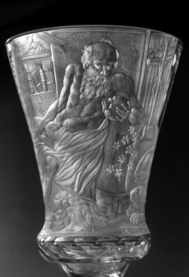 Chalice, glass, 1736–1744. Naliboki, Belarus Grand Duchy of Lithuania. Height 17.2 cm; width 7.7 cm. Round foot, slightly raised, trace of adhesive; baluster stem, solid, faceted, separated from the foot by two plates with a ring one with a flower, separated from the bowl by two plates of different diameter and a knob. Conical bowl, twice puffed out at the base, cut into rows of lenses. Engraved decoration over the entire bowl, biaxial: seated Saint Jerome holding a skull, with a lion at his feet, in a room with bookcases and a side table; inscription in the bowl “THE LORD'S GIFT OF HIS LIFE / FROM WHICH HE MAKES / THE PRINCE OF SACRIFICES / MAY THE HOUR Strike for so many prosperous years / HOW MANY DROPS IN THE GOBLET / WHAT WINE IS IN THE WINE”. Wide geometric-patterned band on the foot. Associated motifs: religious scenes, dedications, lions, books, skull anatomist. Maker: Naliboki glassworks 1722–1862. Related names: Hieronim Florian 1715–1760; Radziwill family. Function: vessel c...