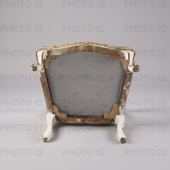 Armchair, Rococo style; floral decoration; cabriole legs; silk fabrics 18th-century patterned floral silk; upholstered seat, backrest, armrests; carved, white-lacquered and gilded. Cabriole legs arched into the frame, wave-like cutout at the bottom; trapezoidal seat with slightly bulging front frame. Disc-shaped backrest, nearly square, topped with an arch; slightly concave side rails, straight in line with sitter's back, slightly tilted with a clearance. Armrests with volute at front end on recessed, slightly S-shaped supports. Edges of all frame elements highlighted with a gilded half-cylinder. Central part of front frame and upper front legs with carved floral decorations; ends of armrests and feet with gilded acanthus leaves. Reupholstered in cream-colored silk satin-weave ground, accented with colored silk and brocaded twill weave with silver thread; decorated with wreaths and alternating vertical garlands, with small floral sprigs in the background. 3rd quarter of the 18th centur...