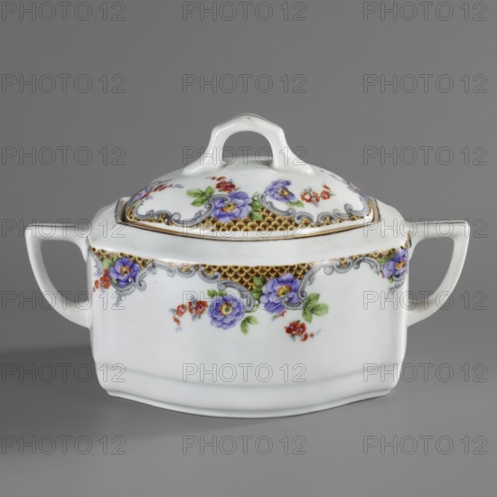 Sugar bowl with lid, Lwów model, Cmielów faience and porcelain factory est. 1804. Floral decorations; sugar bowl with wavy walls beveled on the sides, oval cross-section, with perpendicular handles beveled at the top. Slightly domed lid with a handle-shaped finial. Around the upper edge of the sugar bowl and lid is colorful tracing paper decoration with a fish-scale motif in rococo grey frames and sprigs of purple and brick-red flowers; around the rim of the vessel and the tops of the handles—gilded borders. Tracing paper technique. 1920–1930. Poland; Cmielów. Vessel. Height 11.5 cm, width 18.5 cm, depth 11.5 cm., A white porcelain lidded dish with a rounded rectangular body and a curved handle on each side, decorated with floral motifs in purple, red, green, and touches of yellow, a decorative band in gold with gray scrollwork along the upper edge, and a white loop handle on the lid; the background is gray.