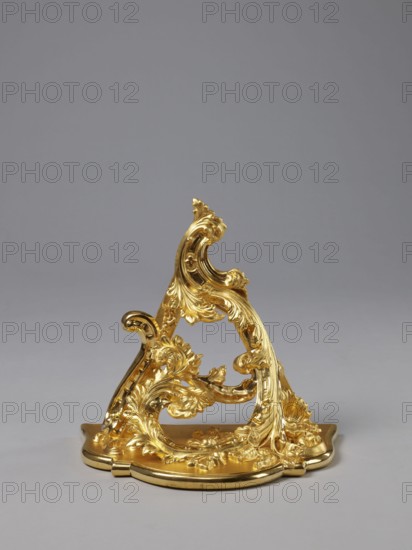 Hanging console, acanthus ornament, floral ornament, Rococo style, ca. mid-18th century, Central Europe, piece of furniture; height 37.3 cm, width 41.5 cm, depth 26 cm, A decorative ornate object with a metallic golden finish featuring flowing, curving, leafy scrollwork and floral motifs, mounted on a rounded base with embossed edging, set against a smooth gray background with lighter and darker gray tones.