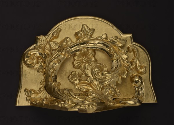 Hanging console, acanthus ornament, floral ornament, Rococo style, ca. mid-18th century, Central Europe, piece of furniture; H. 37.3 cm, W. 41.5 cm, D. 26 cm, A sculpted decorative object with a shiny gold surface featuring an ornate floral and foliate design, including a central raised flower, several curved leaves, scrolling acanthus-like forms, and a rounded arch shape set against a dark background; visible colors include gold and black.