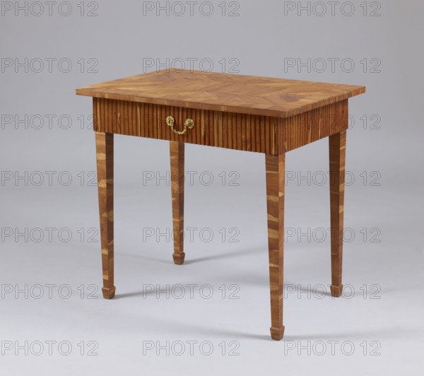 Table, snakes, rosettes ornament, plant decoration, classicism style, rectangular table with a drawer in a fluted frame, supported by four straight, angular, tapering legs terminating in wedge-shaped feet. Entire piece veneered with rosewood and polished. Tabletop has a straight, plate-shaped rim, veneered in a cross pattern, with a rectangular central field and a narrow cross-frame, blintzed on the underside. Drawer handle is a knob made of twisted rope with rosette plates. Drawers form a glued frame with sockets in the corners for mounting the leg tenons. Late 18th century, Warsaw, furniture, table. Dimensions: height 76.5 cm, width 84.2 cm, depth 59.5 cm., A wooden table with a rectangular top showing a patterned wood grain, a skirt with vertical fluted detailing, and a decorative metal handle on the front, supported by four tapered legs with patterned wood inlays, set against a plain light gray background; visible colors include shades of brown in the wood, gold in the handle, and ...