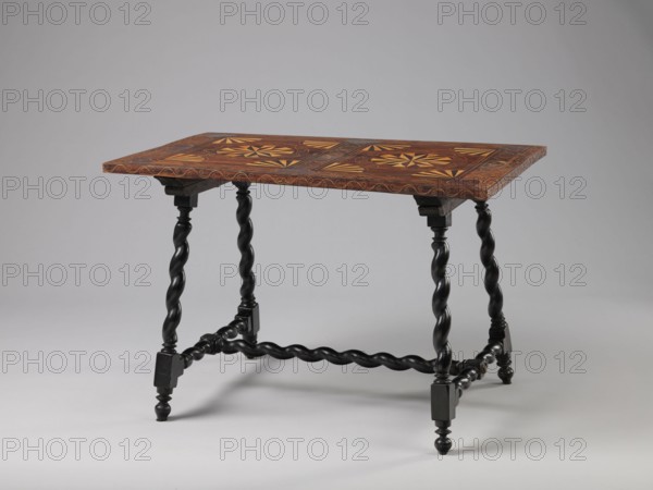 Table, geometric decorations, plant ornaments, rectangular table supported by four straight, spiral legs tilted outwards and sideways, joined at the bottom with an H-shaped tie and at the top with cross stiles connecting them in pairs. Cubes are located at the foot of the table. The tabletop is inlaid and covered with plant twigs and fans oval in the middle, quarters of an oval in the corners, halves halfway along the long sides; with a straight rim decorated with a wave motif. In the type of Baroque furniture from the 2nd half of the 19th century. 17th century, ca. 1660–1690, Spain, Flanders, piece of furniture, table, height 56.5 cm, width 83.7 cm, depth 53.8 cm, A wooden table with a rectangular top featuring decorative geometric inlay in warm brown and yellow tones sits on a group of dark twisted legs and stretchers; the tabletop shows a patterned surface with lighter and darker wood contrasts and a wavy edge border, while the legs and connecting bars are a deep black color with tu...