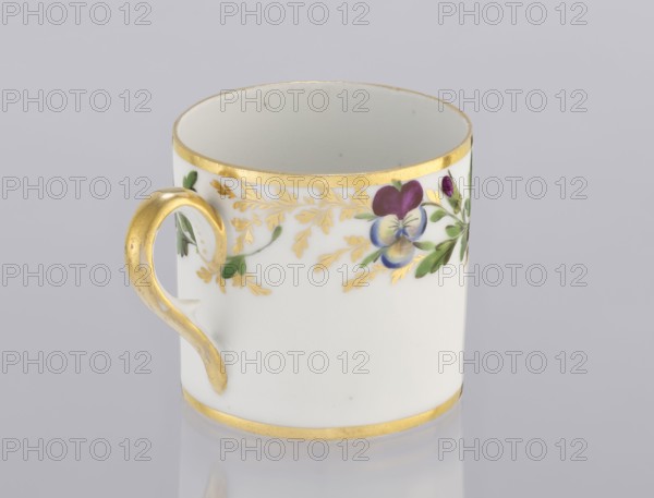 Cup with pansies, Korzec Porcelain and Faience Manufactory, 1790–1832. Cylindrical cup litron, c.1805–1821. Around the upper part of the bowl under the rim: a trail of gilded twigs and colorful pansies; gilded rim. Loop handle, gilded. Porcelain. Place of origin: Korzec, Volhynian Governorate. Vessel. Height 6.1 cm; width 8.8 cm; diameter 6.5 cm., A white ceramic cup with a gold rim at the top and bottom and a gold-painted handle, decorated around the upper exterior with a floral motif in purple, blue, green, and gold leaves against a light gray background.