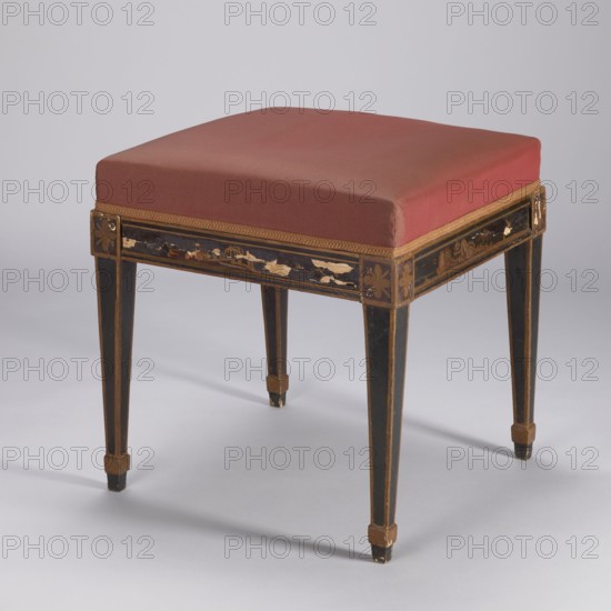 Stool, upholstered, covered with imitation black lacquer, with a square seat supported by four angular, tapering legs with glides. Decoration painted yellow, locally placed on an extruded ground—in a frame with plant and landscape motifs, rosettes on the ankles above the legs. The frame trim, frame edges and leg trims are painted gold. The seat is reupholstered with a red synthetic fabric, finished with an upholstery tape. Chinoiserie, birds, landscapes, rosettes ornament, classicism style. ca. 1800, Italy, Piece of furniture, seating piece. Height 48 cm, width 47.2 cm, depth 47.1 cm., A square stool with a cushioned seat covered in muted red fabric sits on a painted wooden frame. The frame is primarily black with gold trim and decorative gold accents on the apron and leg corners, and portions of the painted surface show areas of wear with lighter wood visible. The legs are tapered and feature gold outlining and small gold blocks near the feet. The background and floor are a pale gray,...