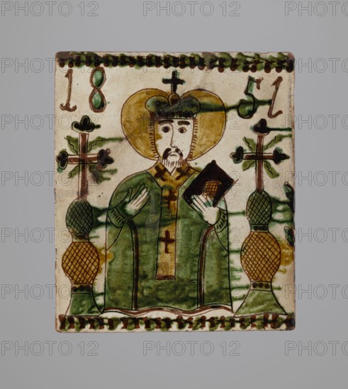 Tile, tiles, Hutsulshchyna, stoves, saints, date: 1851, with a representation of a saint, region: Hutsulshchyna, tile, height 23.7 cm, width 20.0 cm, depth 6.0 cm, A rectangular ceramic tile depicting a robed figure with a halo and a crown, holding a dark object in one hand and gesturing with the other, flanked by two tall decorative stands topped with cross-like elements; the figure's robe is predominantly green with brown and yellow accents, the halo is yellow-gold, and the crown is dark green with brown outlines, while the ceramic background is an off-white or cream color with green and brown decorative borders along the top and bottom and additional green streaks and brown outlines throughout.