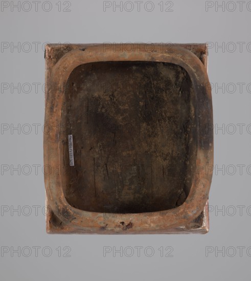 Tile;, Ceramic tile decorated with plant motifs and a double-headed eagle motif and eagles; associated with Hutsulshchyna. Date: 1851. Dimensions: height 20 cm, width 23 cm, depth 6 cm. Classification: stove tile., A rectangular receptacle with rounded inner corners viewed from above, showing a worn interior surface and a raised rim; the object displays shades of brown, rust, dark brown, black, and hints of gray and green on a neutral gray background.