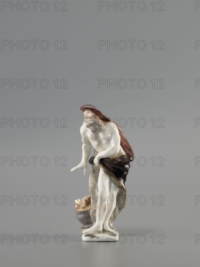 Winter — Allegory. Meissen porcelain factory Koenigliche Porzellain Fabrique, Meissen, ca. mid-18th century 1710–1763. Porcelain figurine, seasons allegory: winter. On a flat, quadrangular pedestal stands an old naked, barefoot bearded man in contrapposto, covered with a fur-lined cloak, a horn thrown over his head flowing down his back and held by the other horn in his left hand at hip level. He leans slightly to the side, warming his right hand over a cauldron with a flame at his feet. Saxony; Meissen. Height: 11.5 cm., A small porcelain figurine of a bearded male figure standing with a draped cloak, shown against a plain grey background; the figure's skin is glossy white, the cloak and drapery show shades of brown and dark brown with some reddish tones, the beard and hair are greyish, and there are touches of beige and muted pink on the face and limbs; the base and a small nearby vessel are off-white and grey with hints of beige, and a few darker brown accents appear where the cloak...