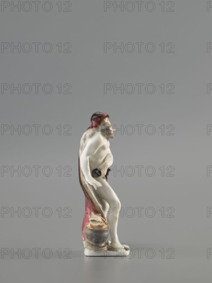 Winter — Allegory. Meissen porcelain Koenigliche Porzellain Fabrique, Meissen, mid-18th century ca. 1710–1763. Seasons allegory: winter. Figurine, black. On a flat quadrangular pedestal, an old naked, barefoot bearded man stands in contrapposto, covered with a fur-lined cloak, a horn thrown over his head and flowing down his back to the ground, held by the other horn in his left hand at hip level. The man leans slightly to the side, warming his right hand over a cauldron with a flame at his feet. Saxony; Meissen. Height: 11.5 cm., A small porcelain figurine of a standing human-like figure with pale white skin tones, a reddish-brown head covering, and brown shading in the hair and beard, draped by a reddish cloak with brown and pink gradients that falls behind and down to a small grayish base; the figure is partially nude, holding a small dark object near the waist, with a few flesh-colored highlights and subtle gray shadows on the limbs, and a small rounded gray vessel with cream-color...